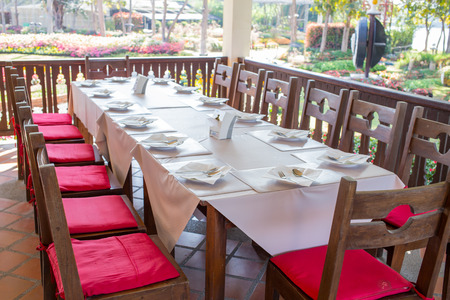 wooden table  with white napkins set for mealの写真素材