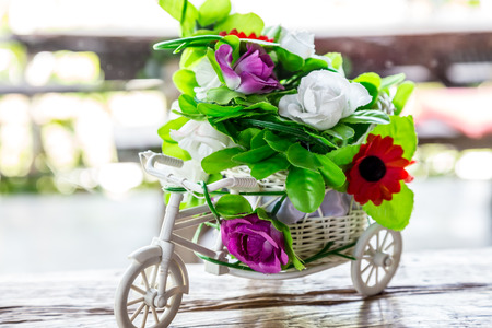 A bouquet of plastic flowers on bicycle tricycle flowers on bicycle tricycleの写真素材
