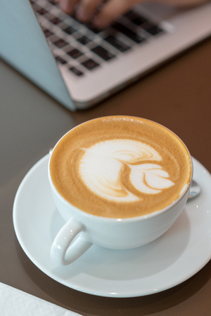 Hot art latte coffee cup on wooden tableの写真素材