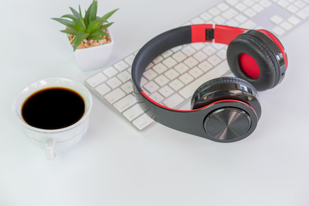 White Workspace with keyboard  coffee and head phoneの写真素材