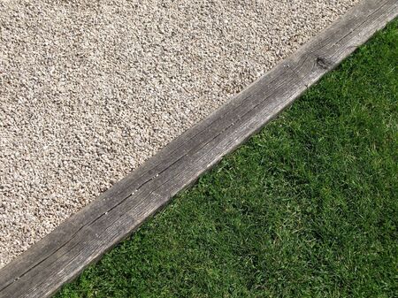 Grass, wooden beam and stones in a diagonal borderの写真素材