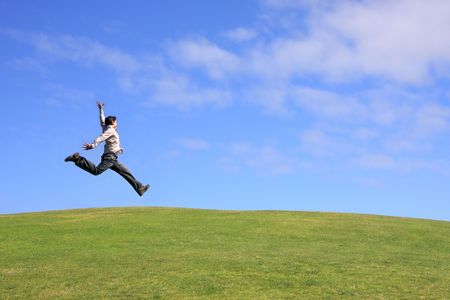 Happy man jumping on a beautiful landscapeの写真素材