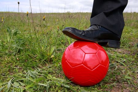 Close-up of a shoe businessman with a red soccer ball, ready to playの写真素材