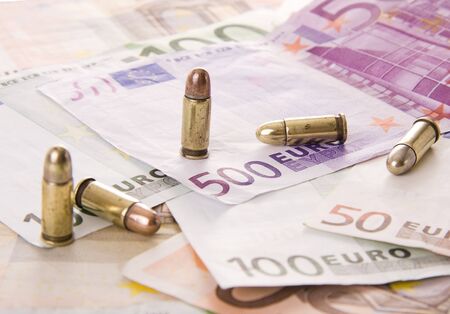 Five bullets and euro banknotes - Selective focus on the 500 eurosの写真素材