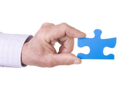 Hand holding a blue puzzle isolated on whiteの写真素材
