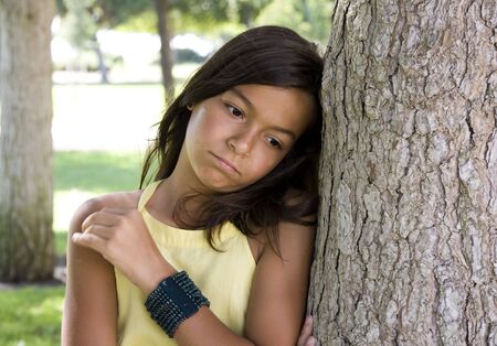 Portrait of a timid young girl on the parkの写真素材
