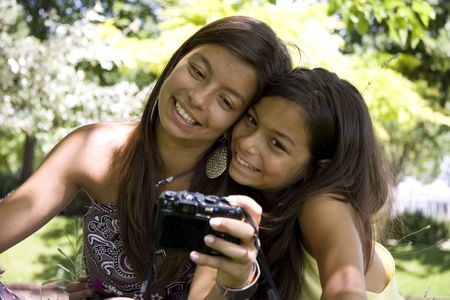 Two young girls taking self portrait with their cameraの写真素材