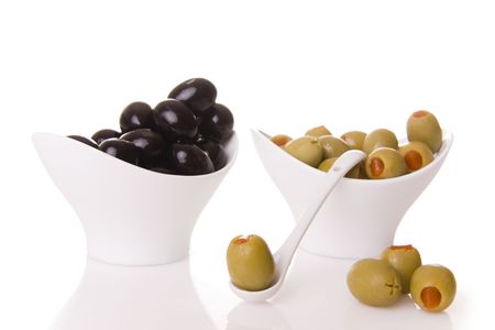 Black and green olives isolated on white - Focus on the olive on ten spoonの写真素材