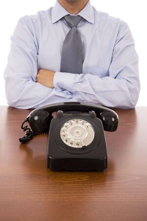 Business man with crossed arms waiting for a callの写真素材
