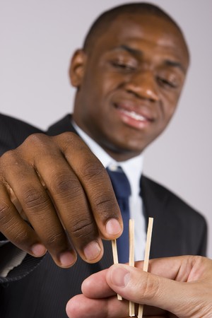 A lucky business man choosing a straw - Focus on the handsの写真素材