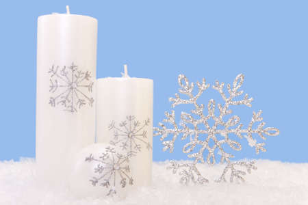 White xmas candles with a shiny snowflakeの写真素材