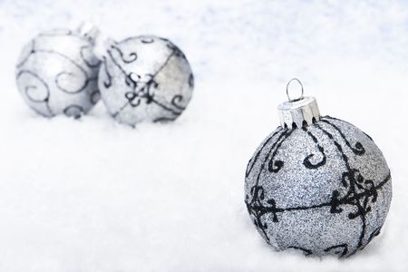 Xmas decoration on the snow (focus on the first Bauble)の写真素材
