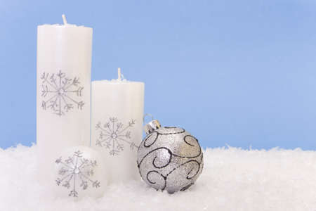 Xmas candles with a shiny baubleの写真素材