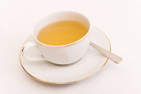 A cup of tea with a spoon isolated on whiteの写真素材