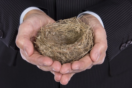 Business man holding a litle empty nest の写真素材