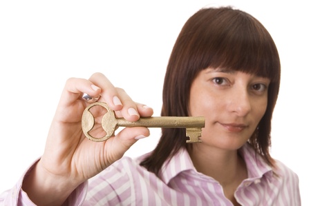Beautiful woman showing an old golden key - Focus on the keyの写真素材