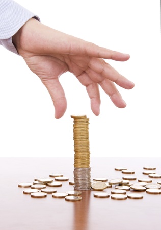 Manï¿½s hand picking coins from a stackの写真素材