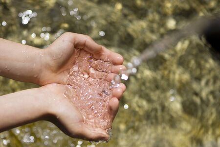 Hands catching clean falling water の写真素材