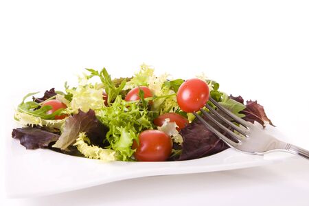 Health food concept - Tomatoes and green salad isolated on whiteの写真素材