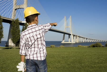 Little engineer pointing to a bridgeの写真素材