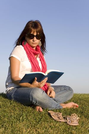 Beautiful woman reading a book on the parkの写真素材