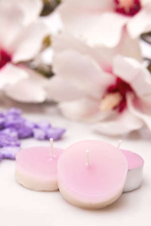 Pink candles with beautiful flowers behind - Focus on the first candleの写真素材
