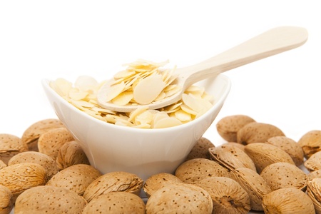 Unshelled almonds and sliced nut«s almonds on white backgroundの写真素材