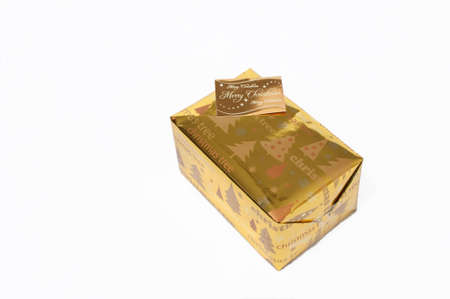Gold coloured wrapped Christmas presents on a white backgroundの写真素材
