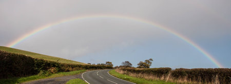 A rainbow spread all the way across a roadの写真素材