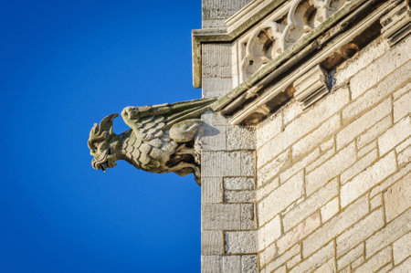 A stone gargoyle on a Welsh church tower on a bright summers dayの写真素材