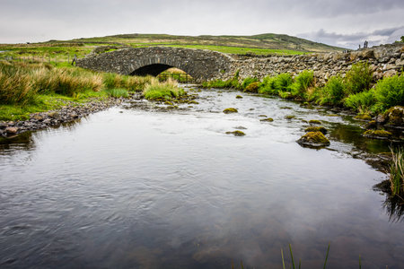 Rural stone bridge across a small river on a moor in the Lake District in north Englandの写真素材