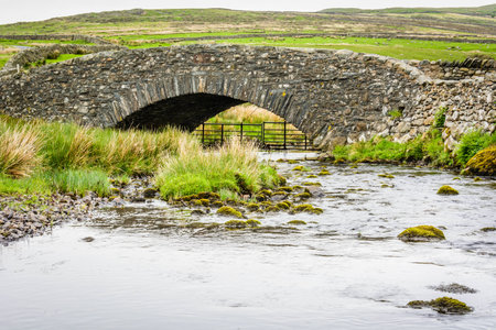 Rural stone bridge across a small river on a moor in the Lake District in north Englandの写真素材