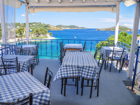 A Harbour restaurant on Skopelos island with boats and island in the Aegean blue seaの写真素材