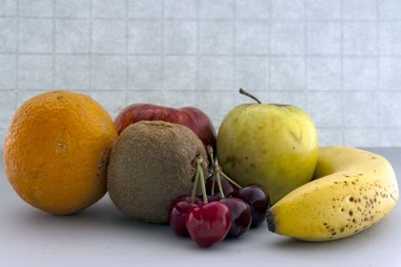 Some fruit with great colors. Orange, kiwi, cherry, apple and banana.の写真素材