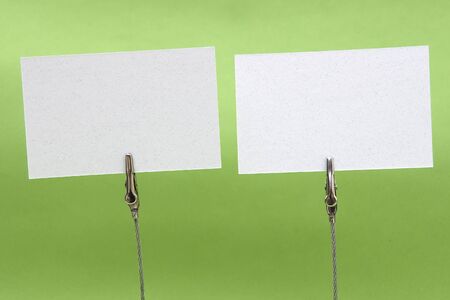 Clamp holding a blank card in green backgroundの写真素材