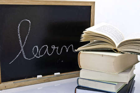 Word learn handwriting on a blackboard with booksの写真素材
