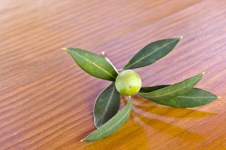 Olive branch with olives on a wooden backgroundの写真素材