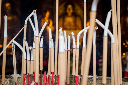 Incense sticks in front of buddha statue.の写真素材