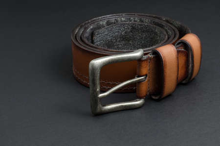 Beautiful brown leather belt on black backgroundの写真素材