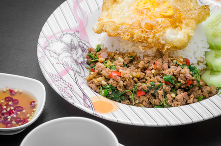 Rice topped with stir-fried pork and basil with fried eggの写真素材