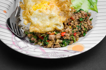 Rice topped with stir-fried pork and basil with fried eggの写真素材