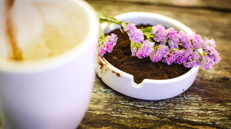Beautiful flower and coffee ground on vintage wooden background, selective focusの写真素材