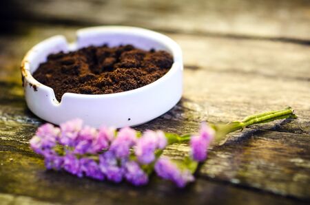 Beautiful flower and coffee ground on vintage wooden background, selective focusの写真素材