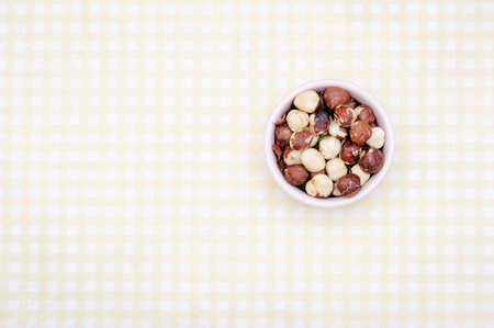 A cup of hazelnut on yellow checkered fabric tablecloth.の写真素材