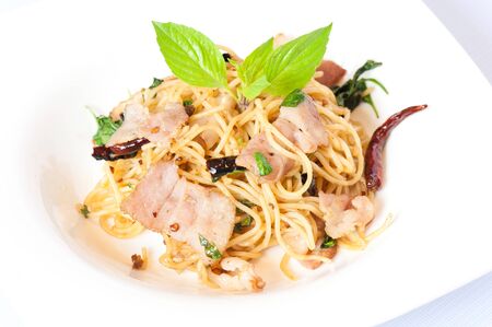 Spaghetti with Stir-Fried Pork and Basil Isolated on White Backgroundの写真素材
