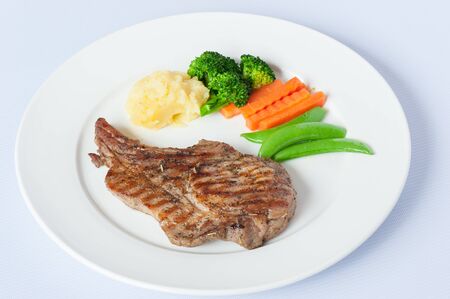 Grilled Pork Steak with Boiled Vegetables Isolated on a White Backgroundの写真素材