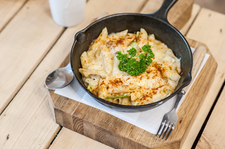Cheesy baked macaroni and cheese pasta portion with parmesan sprinkled on top - soft focus pointの写真素材