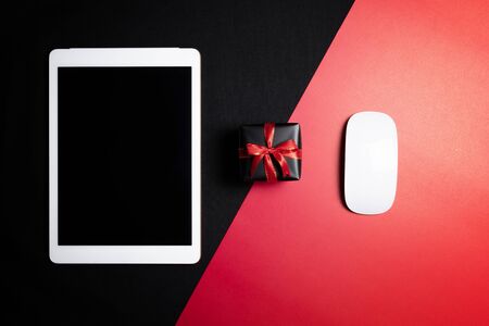 Cyber Monday Sale free space for text with mouse, laptop, tablet and gift box on red and black background. Shopping Online concept and Cyber Monday composition.の写真素材