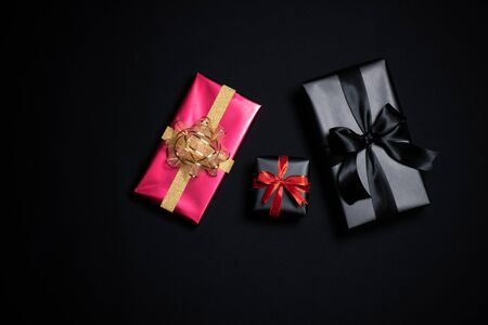 Top view of gift box with red and black ribbons isolated on black background. Shopping concept boxing day and black Friday sale composition.の写真素材
