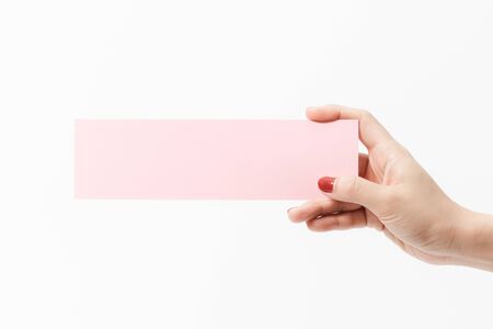Close up women holding pink blank paper on white background. Free space, ready for type with text banner.の写真素材
